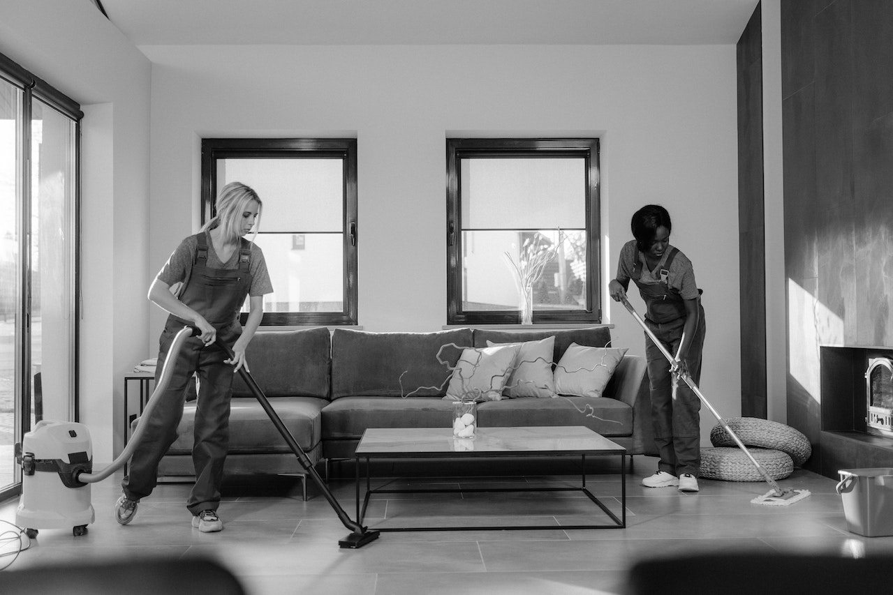 Professional cleaning service team cleaning a modern living room with attention to detail