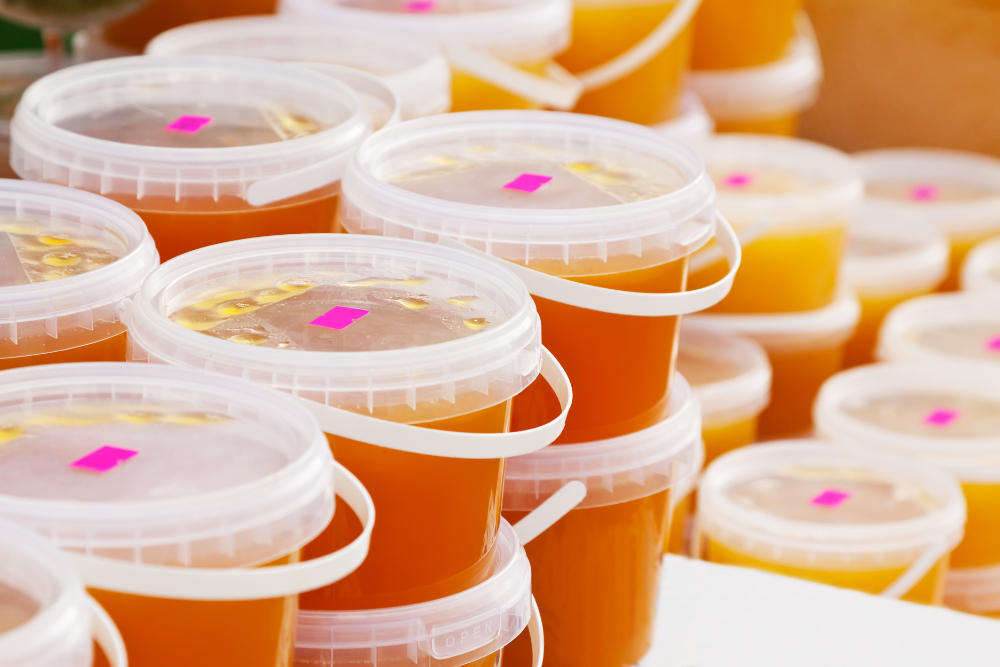 A collection of plastic containers filled with orange juice, showcasing innovative food storage and portable drink solutions.