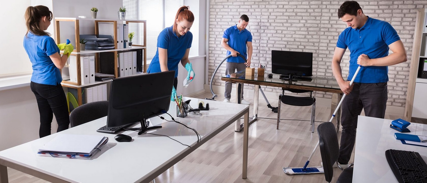 Professional cleaning team performing office cleaning tasks, including mopping, dusting, and vacuuming.